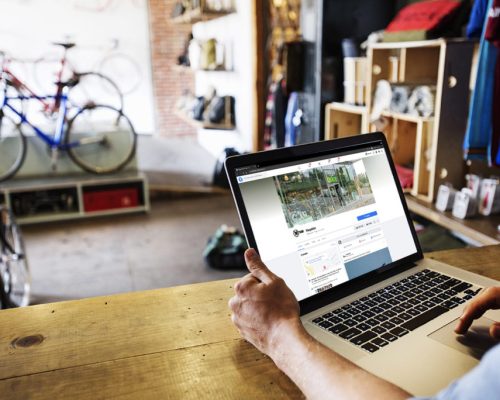 A man in a bicycle repair shop using a laptop computer Running a business